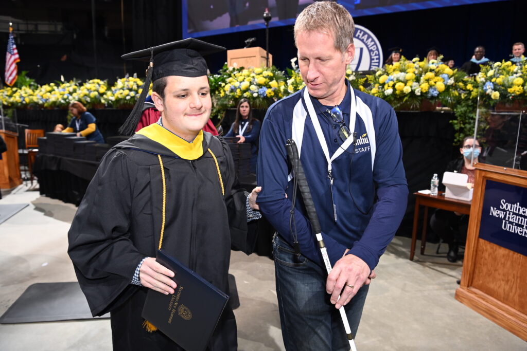Man walking at graduation with accessibility accommodations