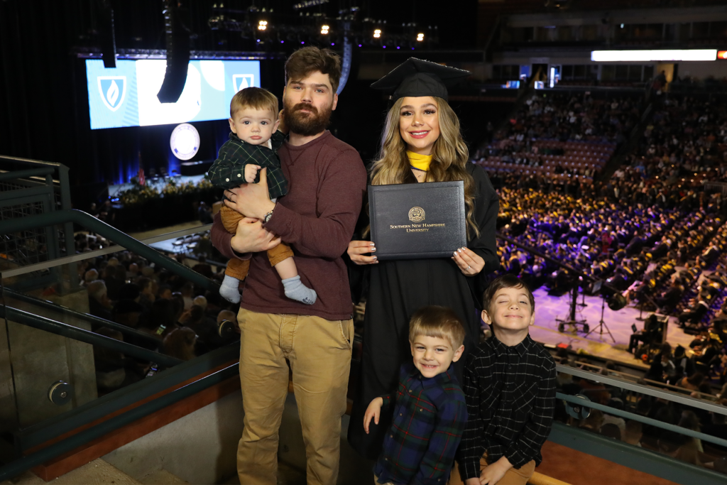 Tiare Hazen, accompanied by her three boys and loving husband, celebrates her achievement at SNHU Commencement.