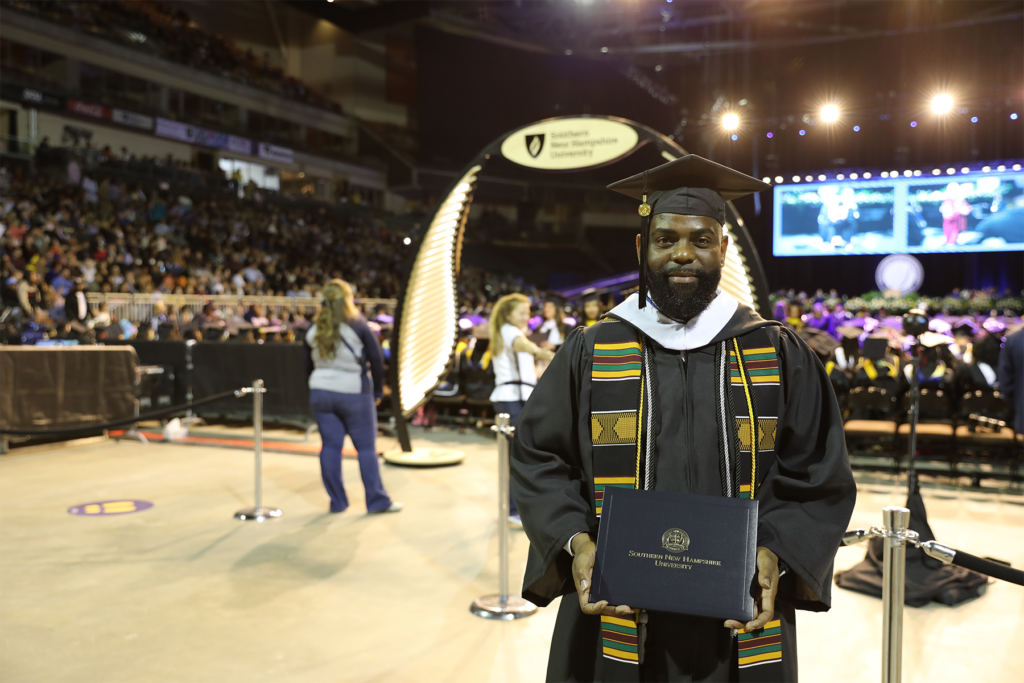 Cedric Parker proudly holds his diploma at his Commencement ceremony.